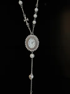 Detailed view of the vintage rhinestone watch pendant necklace with pearls and cross charm.