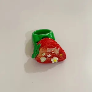 Gros plan détaillé de la bague fraise en résine avec de jolis strass et des détails.