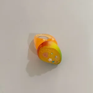 Gros plan détaillé sur une bague épaisse en résine avec dégradé tropical et strass.