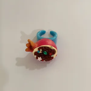 Détail de bague fruit grenade style Y2K, strass colorés, bijou fantaisie mignon en résine.