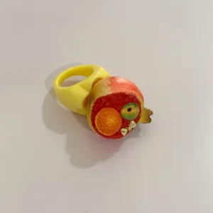 Bague statement Y2K en résine avec un anneau jaune large et un motif de fruit ludique.
