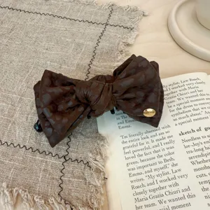 Vue rapprochée détaillée d'une pince à cheveux rétro marron léopard, design élégant.