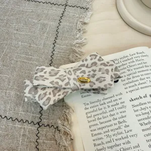 Pince banane nœud papillon en tissu imprimé léopard vintage pour queue de cheval basse.