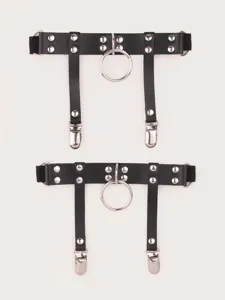 Detailed shot of black punk leather leg garter belt with metal rings and silver rivets