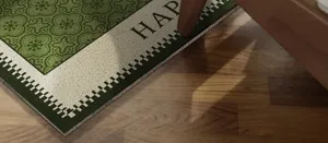 Detaillierte Nahaufnahme der grün-weißen Fußmatte, rutschfester strukturierter Teppich.