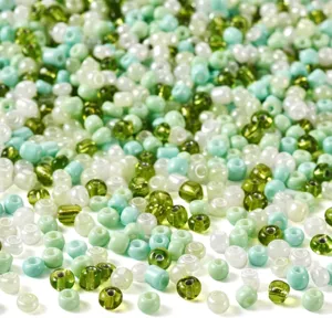 Detailed close-up of mixed green and white glass seed beads, perfect for DIY jewelry making.