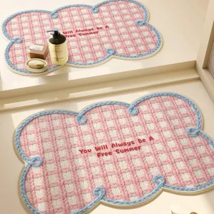 Creamy woven linen-effect cloud bath mat with blue piping and chic embroidered text design.