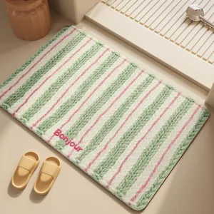 Absorbent bath mat with green and pink stripes and Bonjour text, anti-slip design for bathroom.