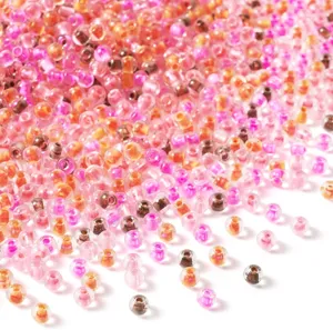 Close-up detail view of colorful glass seed beads in mixed pink and orange for DIY jewelry.