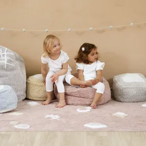 Detailed view of fluffy plush children's crawling rug and soft beanbag cushions in kids room.