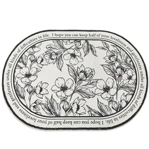 Alfombra de suelo ovalada con patrón floral en blanco y negro y tacto de cachemira para dormitorio.