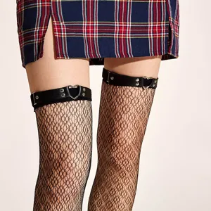 Punk style black leather heart garter belt and fishnet stockings set with plaid mini skirt.