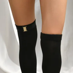 Black over-the-knee socks detail shot featuring elastic fabric and decorative gold buckle leg ring.