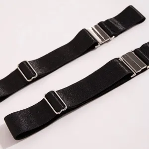 Close-up detail of black elastic boot straps with silver metal adjusters and hooks.