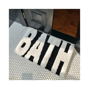 Nordic black and white tufted bath mat with bold letters, absorbent floor rug for home.