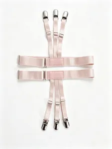 Detalle de primer plano de tirantes elásticos rosas ajustables para camisa con clips metálicos.
