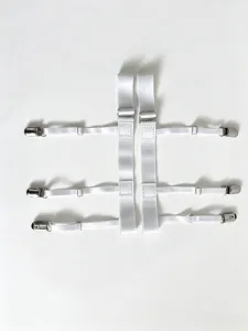 Vista detallada de tirantes elásticos blancos para camisa con clips metálicos ajustables.