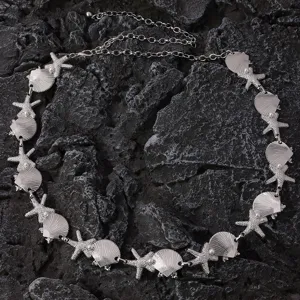 Closeup detail of silver metal seashell and starfish waist chain with pearls for beach resort.