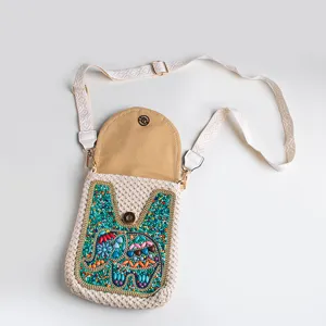 Bohemian straw woven crossbody phone bag with colorful beaded elephant design and strap.