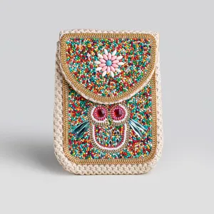 Detailed view of bohemian style straw crossbody phone bag adorned with colorful beaded owl pattern.