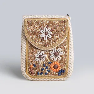 Boho straw phone bag detail, featuring intricate beaded patterns, shell flowers, and colorful stone accents.
