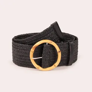 Black woven raffia belt with round wooden buckle, stylish bohemian waist accessory detail view.