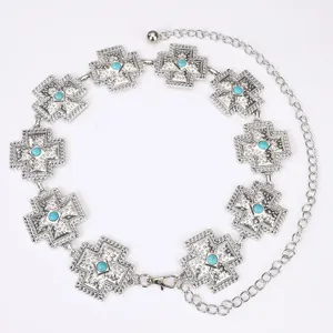 Detailopname van de zilveren metalen kruis tailleketting met prachtige turkoois stenen.