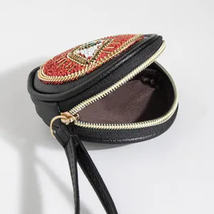 Detail shot of black PU coin purse with bohemian seed bead embroidery and gold zipper.