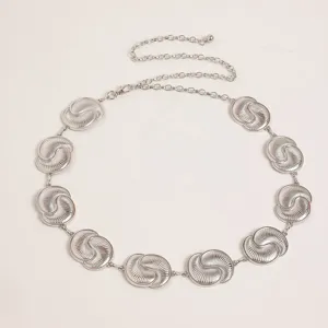 Detailed shot of a vintage silver metal waist chain for women, featuring carved circular links.