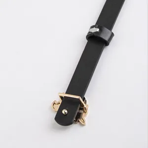 Gros plan détaillé de la ceinture pour enfants en cuir noir avec boucle dorée et boucle.