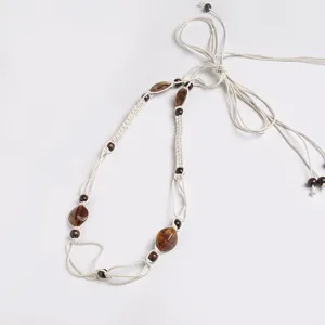 Bohemian woven waist belt detail shot, featuring beige macrame cord with brown wooden beads.