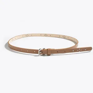 Detail view of the thin faux leather belt featuring metal studs and cutout design.