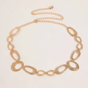 Close-up details of vintage gold metal waist chain with textured oval links and dainty charm.