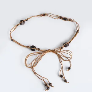 Bohemian style braided waist rope detail showing delicate wooden beads and cord knotting.