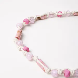 Detail view of bohemian braided waist rope with pink beads and natural cord texture.