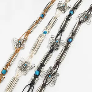 Close-up detail of bohemian style braided waist belt with silver butterfly charms and beads.
