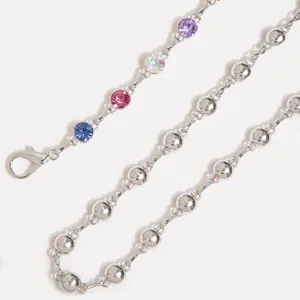 Détail exquis de chaîne de taille en strass multicolores, maillon et fermoir argentés.