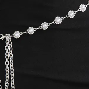 Gros plan d'une chaîne de taille argentée avec des maillons floraux en strass et perles.