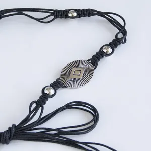 Handmade bohemian black braided rope waist belt detail featuring silver metal beads and medallion.