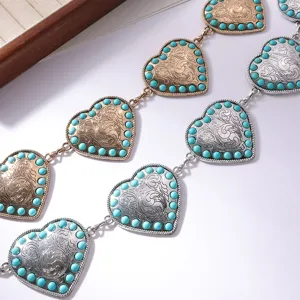Primo piano dettaglio di catena da cintura in metallo cuore turchese vintage, oro argento.