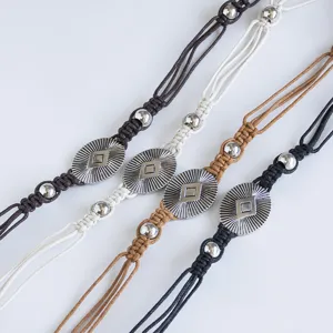 Detailed view of bohemian braided waist belt with metal beads, ethnic style vacation rope.