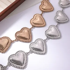 Dettaglio catena girovita cuore in metallo, stile vintage oro e argento cintura donna.