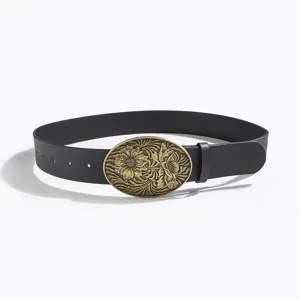 Closeup detail of the vintage western style black leather belt with brass floral buckle.