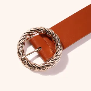 Close-up detail of stylish brown PU leather belt featuring a metallic gold twisted round buckle.