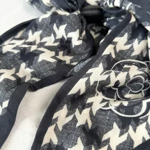 Close-up detail of the black and white houndstooth silk ribbon scarf with camellia print design.