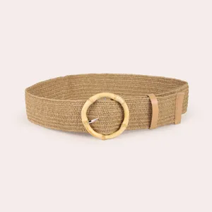 Close up of a woven raffia straw belt featuring a round resin bamboo buckle and sleek PU leather.