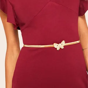 Close-up of elegant gold metal spring waist chain with sparkling rhinestone butterfly buckle.