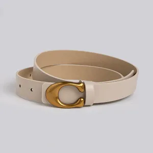 Gros plan d'une ceinture pour femme en cuir PU beige avec un élégant boucle dorée en C.