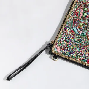 Detailed view of bohemian style seed bead clutch bag with colorful embroidery and wrist strap.