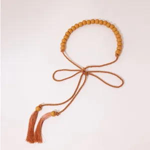 Bohemian style woven waist belt with wooden beads and tassels, elegant accessory for women.